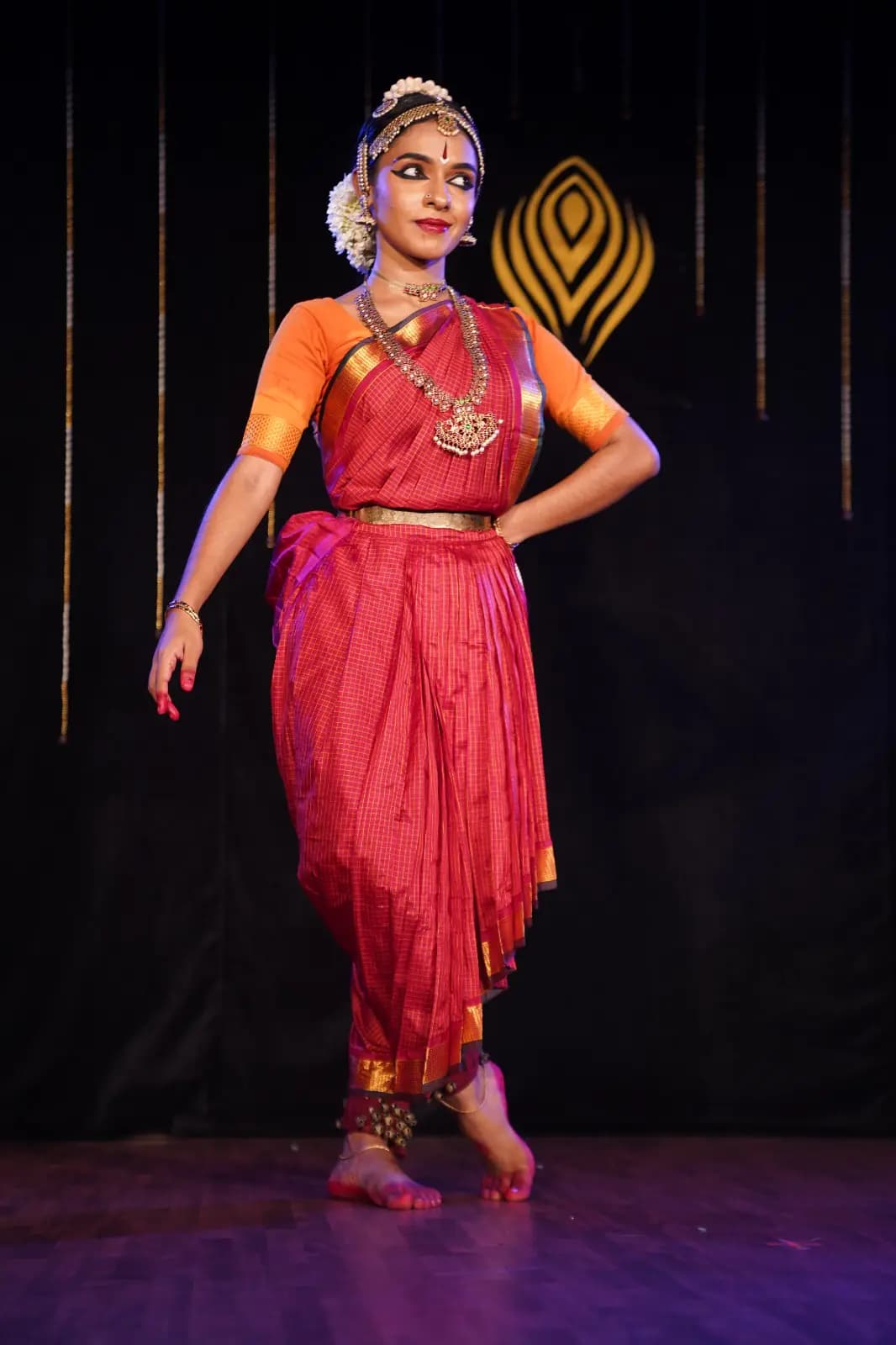 Devi Nandana in classical dance costume during a stage performance.